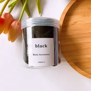 Pot d'élastiques à cheveux noirs sans couture sur plateau en bois avec décor de tulipe