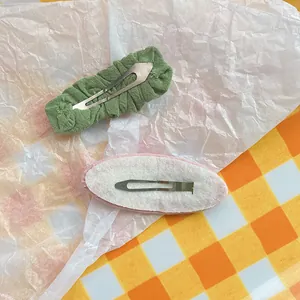 Detail van de achterkant van stoffen BB-haardspelden met viltbasis en metalen klikgesp