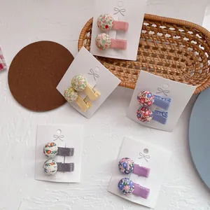 Set de pinzas para el cabello de tela floral en cinco colores pastel en tarjeta