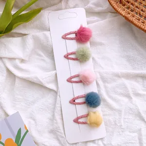 Set of five plush pom pom hair clips for kids in various soft pastel candy colors