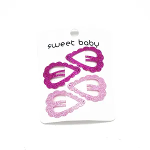 Détail de barrettes cœur pailletées roses sur une carte de présentation sweet baby