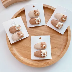 Cute bear hair clips in milk tea colors for girls, featuring felt texture and resin bows
