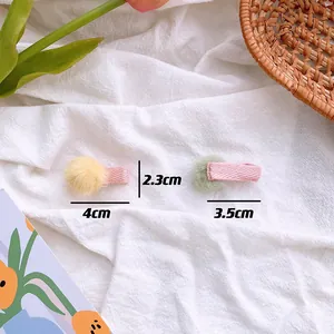 Detailed size view of two cute fuzzy pom-pom hair clips in yellow and green colors