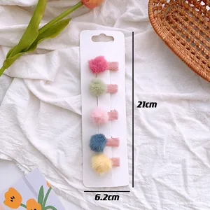 Detailed view of 5 colorful pom-pom hair clips set with sizing dimensions on white card