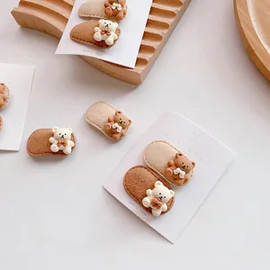 Cute teddy bear hair clips set for girls in brown and beige tones on a wooden stand