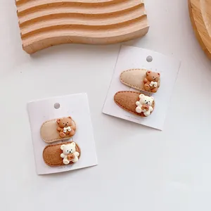 Detail of 3D bear hair clips for girls on display cards with warm wooden backgrounds
