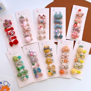 Close-up of girl's hair clip set featuring cute knitted fruit and animal designs on cards
