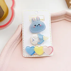 Detalle de tres bonitos clips de acrílico para el pelo con purpurina y corazones