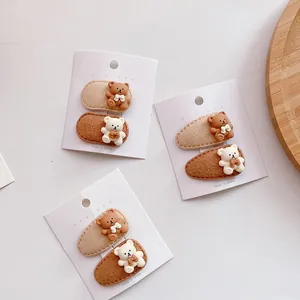 Close-up of cute 3D teddy bear felt hair clips for kids on original white card display