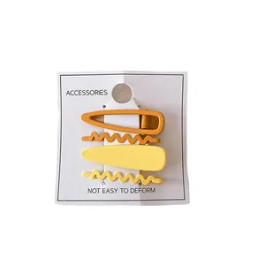 Lot de quatre barrettes en métal aux couleurs acidulées avec fini jaune et orange vif