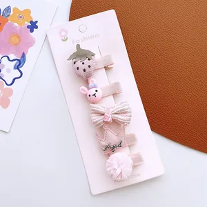 Detailed view of 5-piece pink baby hair clips including bunny and strawberry on a card