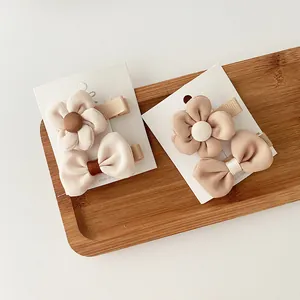 Milk tea beige fabric bow and flower hair clips set for girls on a wooden tray