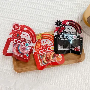 Detailed close-up of 30-piece colorful elastic hair tie packs for kids on wood tray