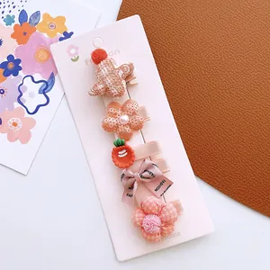 Detail view of 5-piece girls' hair clips set with cute fabric flowers and bows on a card