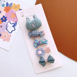 Detail of 5-piece floral fabric hair clips set for girls on a pink display card