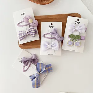 Set de pinzas para el cabello moradas para niñas con lazos de tela y motivos de cuadros