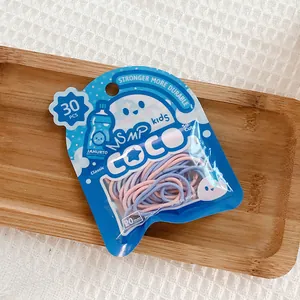 Macro detail of 30pcs 20mm high elastic kids hair ties in pink and blue packaging