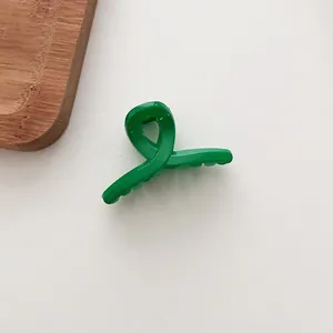 Vue de dessus d'une petite pince à cheveux vert fluo de couleur bonbon sur fond neutre