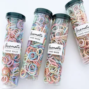Detail of colorful spiral hair ties in transparent jars with aromatic handmade labels