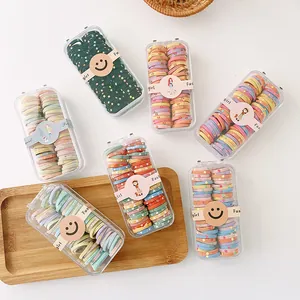 Detailansicht bunter Haargummis in Macaron-Farben in einer transparenten Geschenkbox
