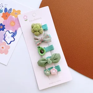 Detailed set of green floral and bow hair clips for girls on a fashion display card