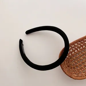Detailansicht eines handgefertigten schwarzen Stoff-Haarreifens mit gewebtem Handmade-Etikett