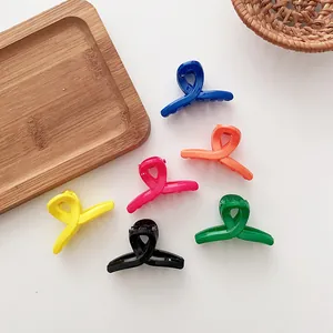 Lot de six petites pinces à cheveux aux couleurs vives sur un plateau en bois rustique
