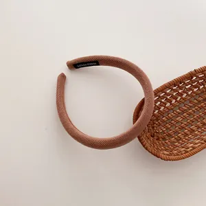 Detailansicht eines handgefertigten rosa Rippstrick-Stirnbandes mit Innenetikett