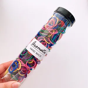 Macro detail of colorful high-elastic hair ties in a transparent storage bottle