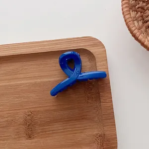 Pince à cheveux bleue en forme de ruban pour filles sur un plateau en bois naturel