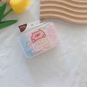 Detail of colorful elastic hair bands for kids in a cute transparent cartoon box