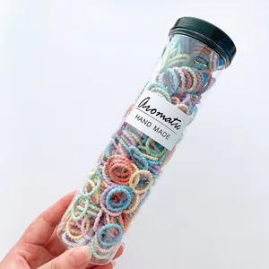 Macro view of multi-color high elastic spiral hair ties in a clear cylindrical tube