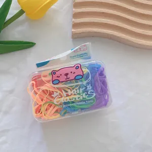 Macro view of colorful elastic hair bands in a transparent box with cartoon bear tag