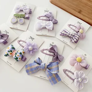 Detalle del set de horquillas moradas con lazos y flores en tarjetas de muestra