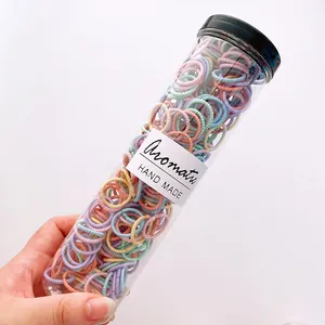 Macro shot of macaron colored elastic hair ties in a clear jar with handmade label