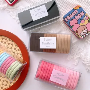 Detail of multi-color elastic hair ties organized in a clear rectangular storage box