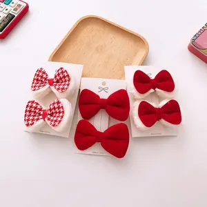 Close-up of 6-piece red plush bow hair clips set on a white display card for girls