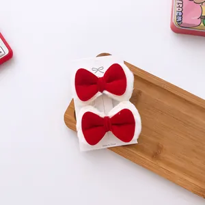 Detail of red velvet kids hair clips with white faux fur trim on a card display