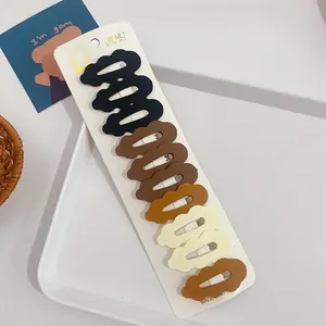 Set of 10 matte wave hair clips in earth tones displayed on a white product card