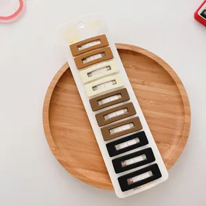 Lot de 10 barrettes géométriques mates en beige et marron sur carte de présentation