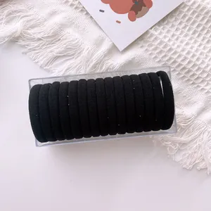 Detail of 15 black high-elastic seamless hair ties organized in a clear storage box