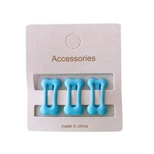 Three pieces of cute blue bone-shaped hair clips displayed on a beige paper card