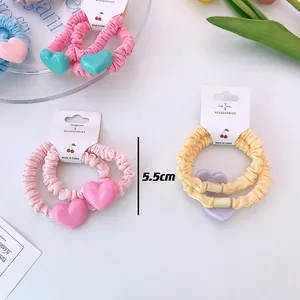 Détail macro de chouchous à volants élastiques avec pendentifs en forme de cœur doux