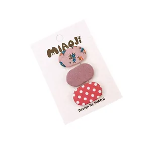Set di tre mini mollette ovali in tessuto con motivi floreali, viola e a pois