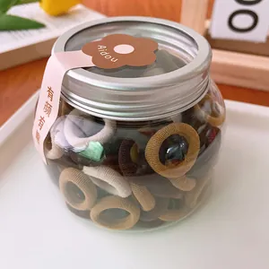 Jar of 100 colorful elastic hair ties in warm neutral tones for kids and women