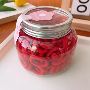 Jar of candy-colored elastic hair ties for kids with a silver lid and pink labels