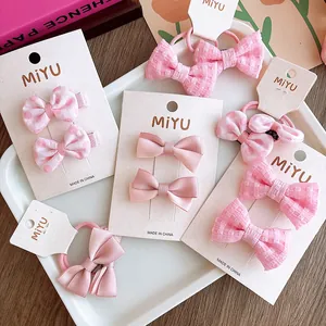 Dettaglio del set di accessori per capelli con fiocchi rosa e motivi a pois su carta