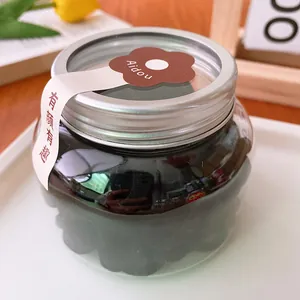 Detailed view of the clear round candy storage jar with a silver metallic screw cap