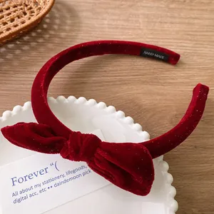 Detailed macro view of the handmade label on a red velvet bow headband in a tray