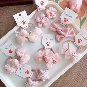 Detail shot of pink sweet bow hair ties for girls with floral and sequin accents